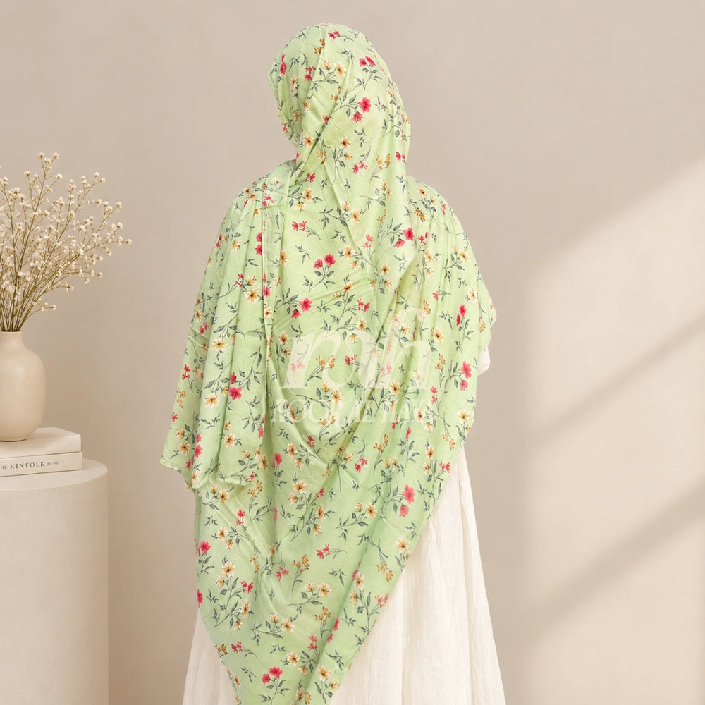 a model wearing green floral printed hijab by noor al haya