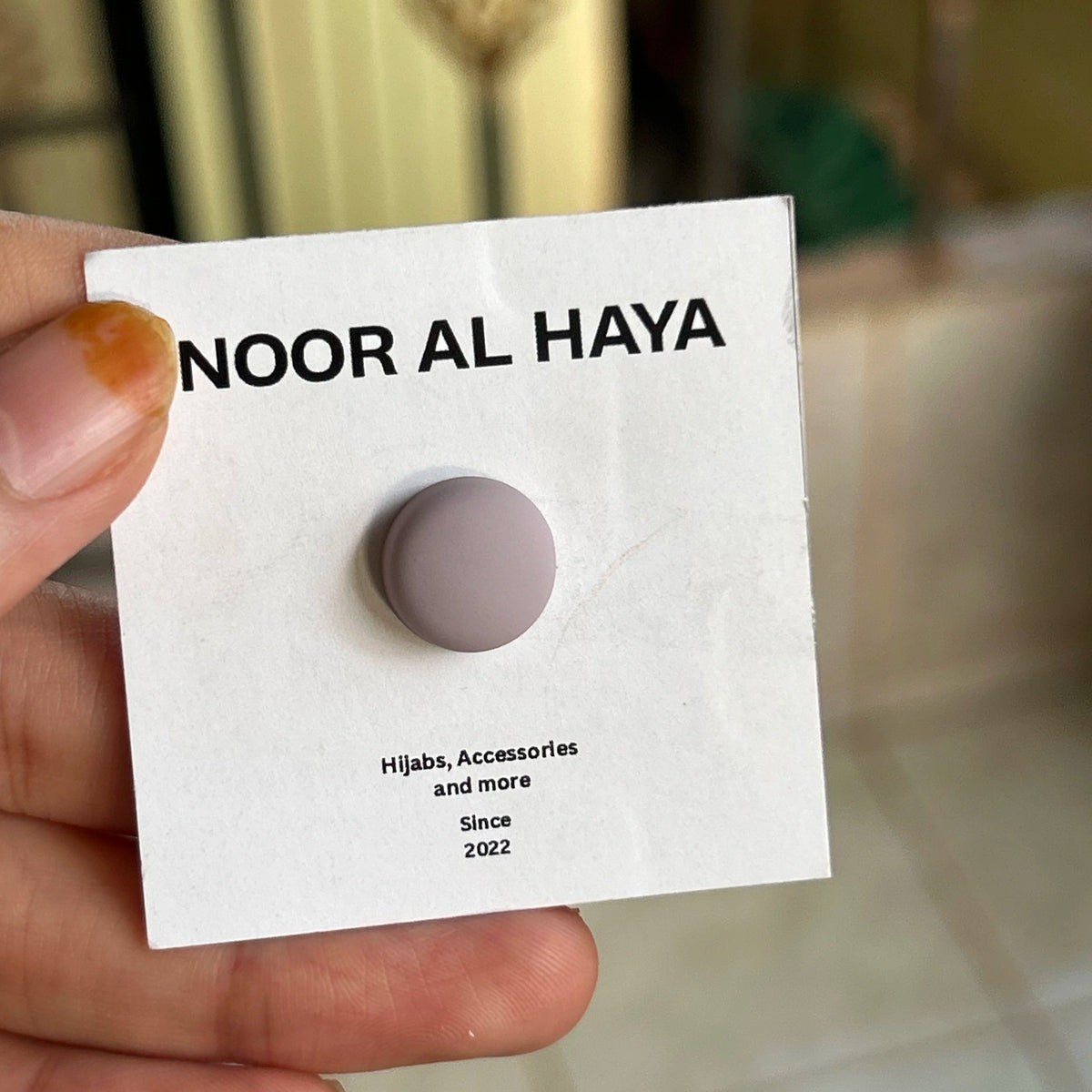 Woman holding baby pink hijab magnet by Noor Al Haya