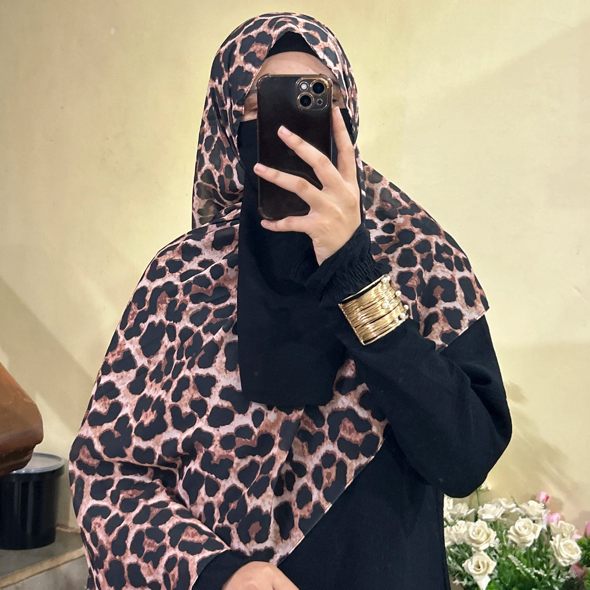 a women wearing and posing in leopard print chiffon hijab by noor al haya