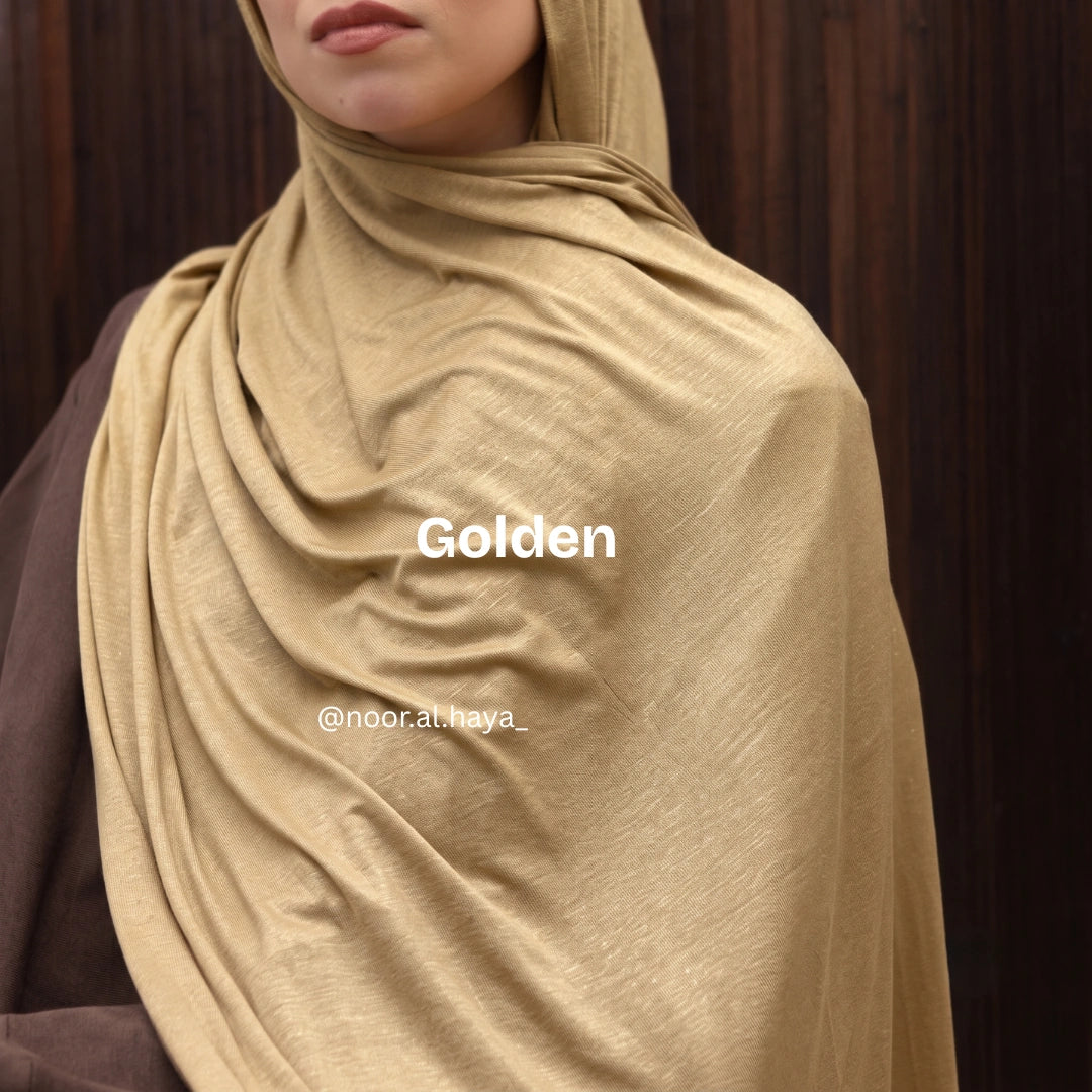 a women wearing  golden luxe jersey hijab by noor al haya