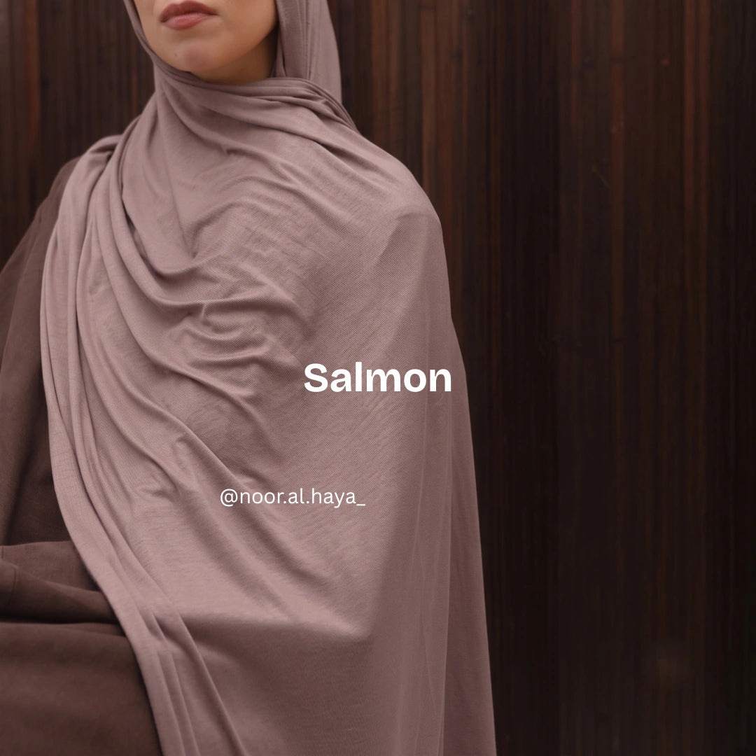 a women wearing a salmon luxe jersey hijab by noor  al haya