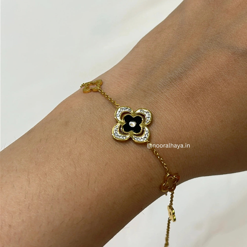 Woman wearing a black clover bracelet by Noor Al Haya