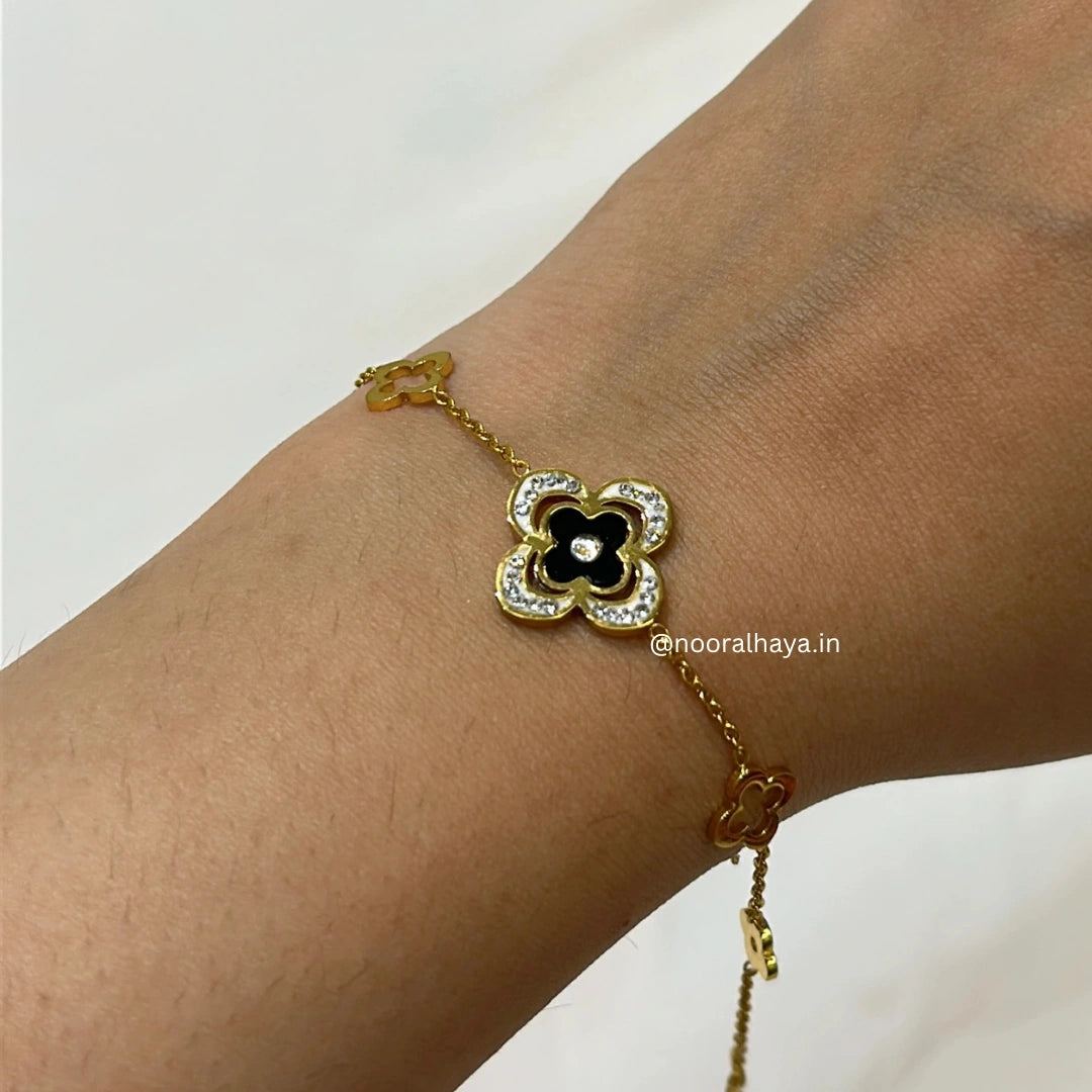 Woman wearing a black clover bracelet by Noor Al Haya
