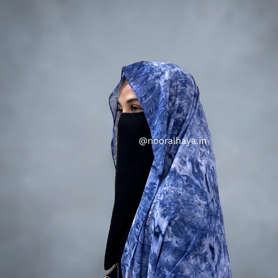 a women wearing blue watercolour hijab by noor al haya