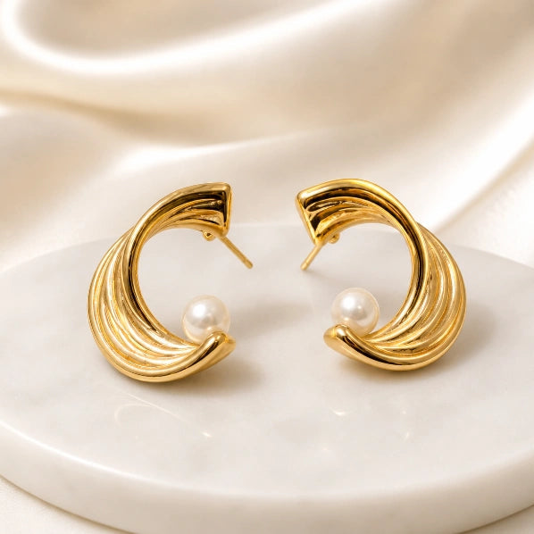a close up shot of Noor Pearl Hoop Earrings displayed on white board by Noor Al Haya