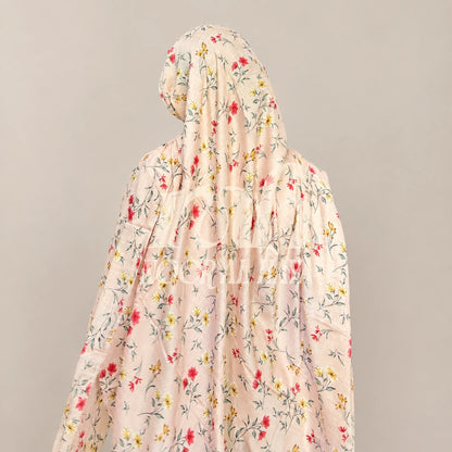 a  model wearing pink floral printed hijab by noor al haya