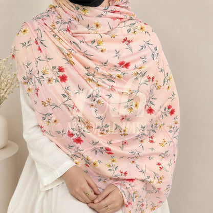 a  model wearing pink floral printed hijab by noor al haya