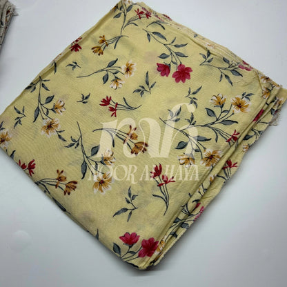 a close up photo of yellow floral printed hijab by noor al haya
